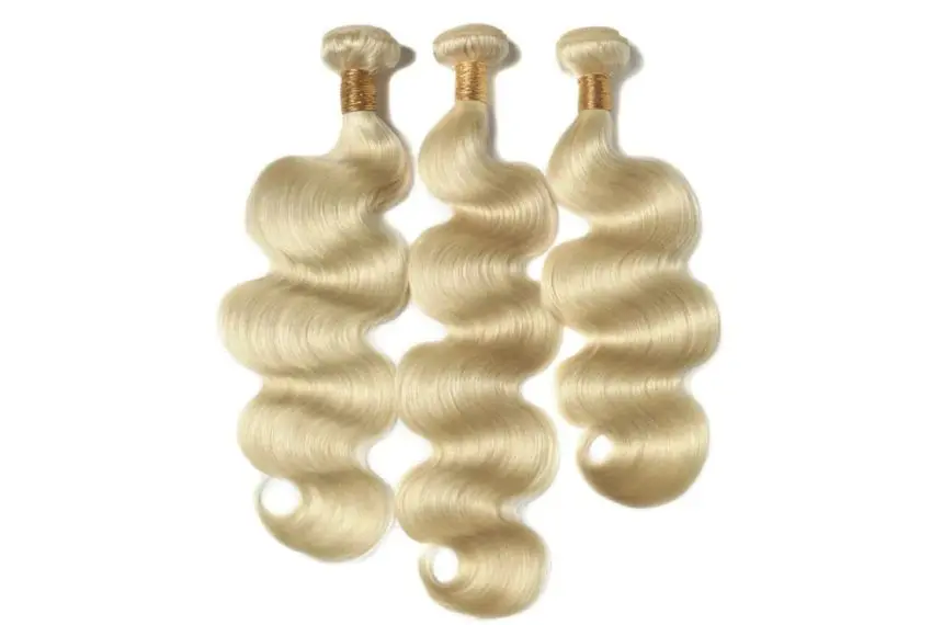 Three blonde hair extensions laying next to each other.